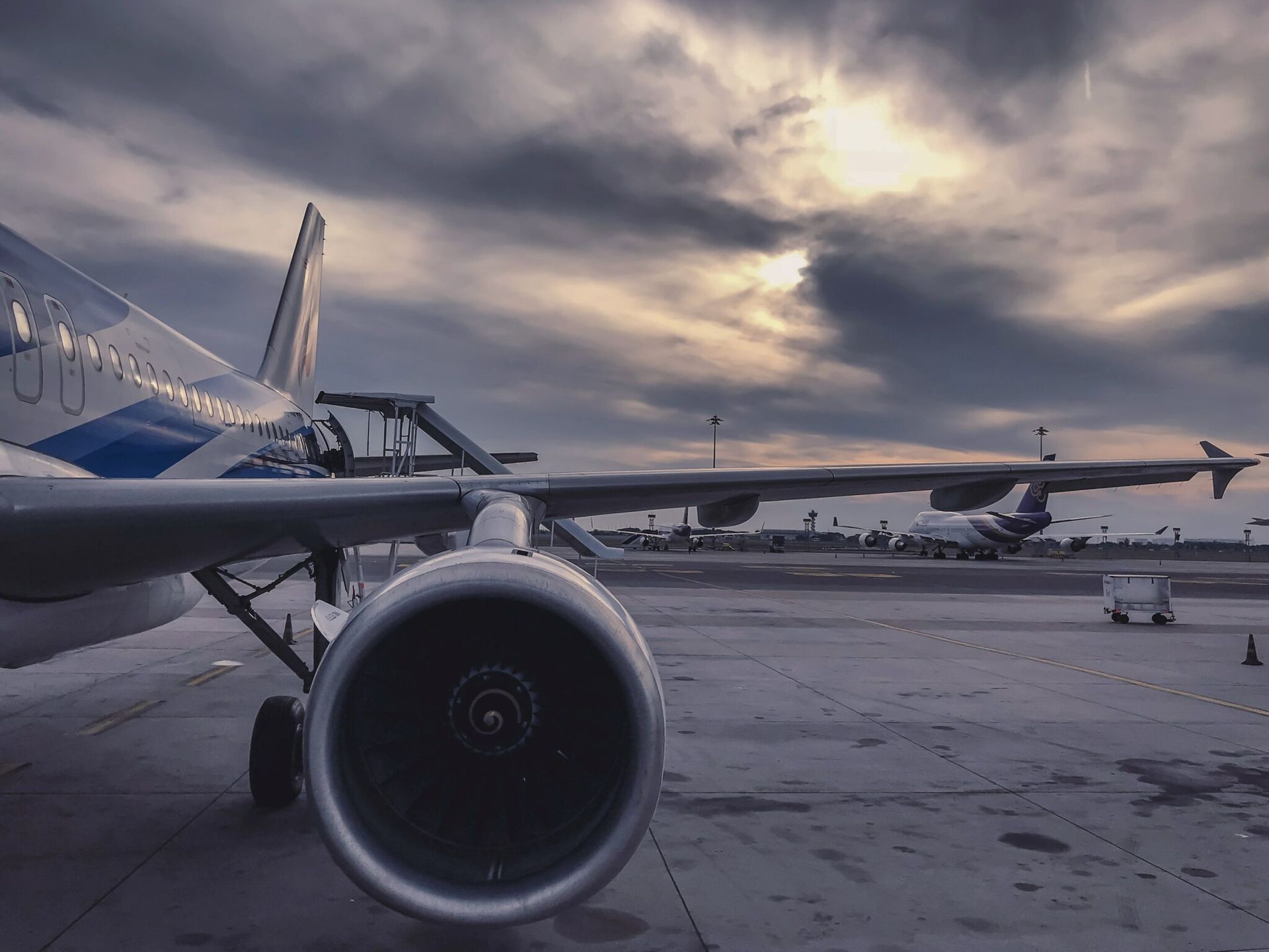 Avion sur le tarmac sous un ciel nuageux